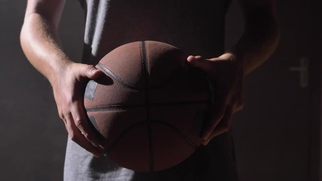 Close shot of basketball player's hands playing with ball