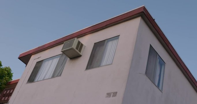 Obscure angle of apartment exterior in California, clear sunny day at sunset.