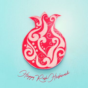 Rosh hashanah (jewish New Year holiday) concept. Traditional symbol POMEGRANATE shape cut from paper and painted.