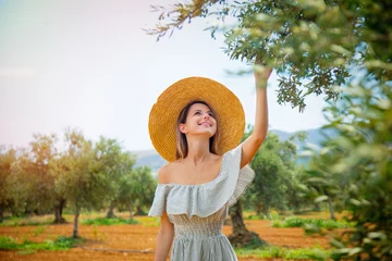 Papier Peint photo Lavable Olivier Jeune fille rousse portant en robe et chapeau se reposer dans le jardin d& 39 oliviers grecs à Héraklion, Crète, Grèce