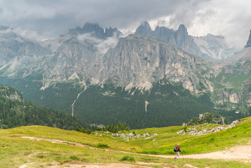 Fototapeta na wymiar Italian Dolomites landscape. Light after rain in Dolomites. Rocky peaks in the background surrounded by rain clouds. Layers of forest and mountains ridge. Rocky Mountains Dolomiti. Storm rain over r