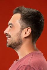 Fototapeta premium The happy business man standing and smiling against red background.