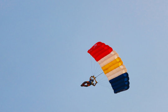 parachuter flies on background of sunset sky.Silhouette of skydiver with a parachute against the blue sky. Background image. Active Hobbies. The concept of freedom