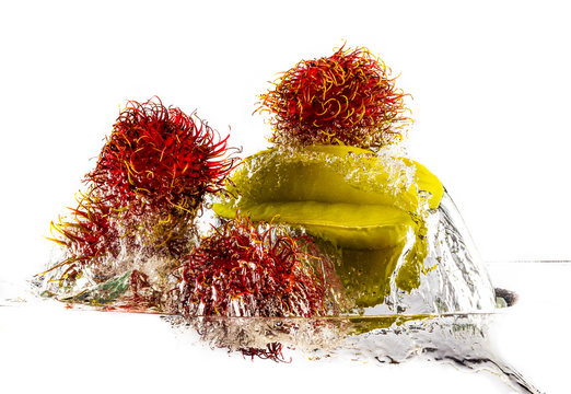 Ramboutan - rambutan et carambole dans l'eau sur fond blanc