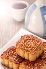 Mooncake in chinese traditional mid-autumn festival(moon festival) on wooden table background with copy space(text space) and table setting, close up.