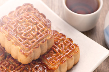 Mooncake in chinese traditional mid-autumn festival(moon festival) on wooden table background with copy space(text space) and table setting, close up.