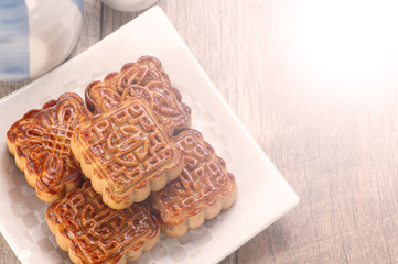 Mooncake in chinese traditional mid-autumn festival(moon festival) on wooden table background with copy space(text space) and table setting, close up.