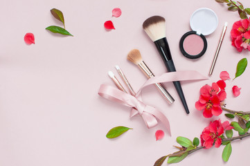 Obraz na płótnie Canvas Various cosmetic products for make-up with red flowers on a pink background with copy space. Makeup Accessories Top view Flat Lay. Powder Rouge Eyeshadow Corrector Brushes