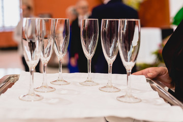 Glasses of champagne ready to be served by a waiter.