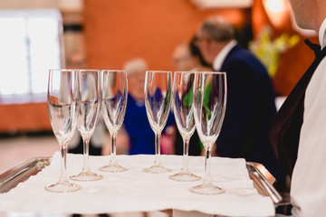 Glasses of champagne ready to be served by a waiter.
