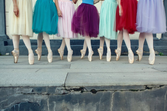 Ballet dancer's feet dancing on street. Young ballerinas in color tutu. Ballet feet on the point.