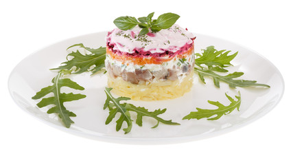 Salad herring under a fur coat, decorated with fresh Basil. Isolated on white background.