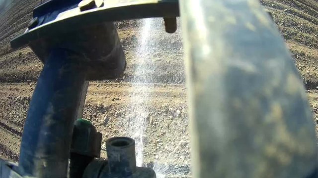 A view of the spray nozzle while working in the field. Sprayer nozzle in operation, tractor sprayer works in the field.
