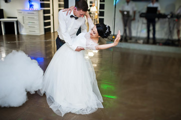 Romantic newly married couple performing their first dance in the restaurant with heavy smoke.