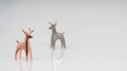 A nice golden and silver reindeer statue isolated on a white background. Lovely deer couple statue.