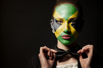 Portrait of woman with painted Jamaica flag and bow tie