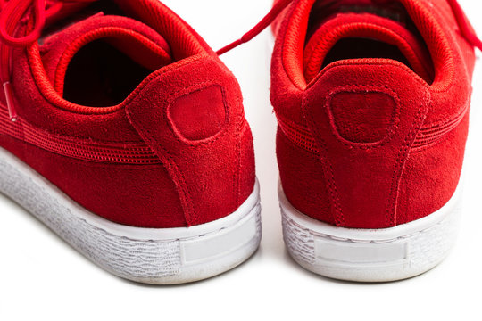 Zapatillas de deporte rojas. Vista desde atrás sobre fondo blanco. 