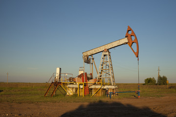 Fototapeta na wymiar The oil pump, industrial equipment. Oil rocking at sunset in Russia, Republic of Bashkortostan