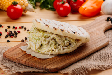 Famous and delicious Venezuelan AREPA called Reina Pepeada on a kitchen board