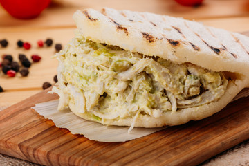 Famous and delicious Venezuelan AREPA called Reina Pepeada on a kitchen board