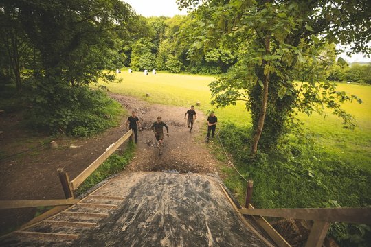 Group of men training over obstacle course