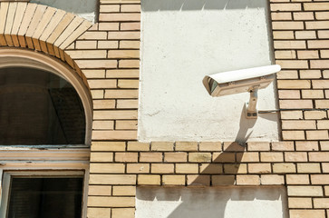 City cctv security surveillance camera system attached on the building brick facade for street public safety