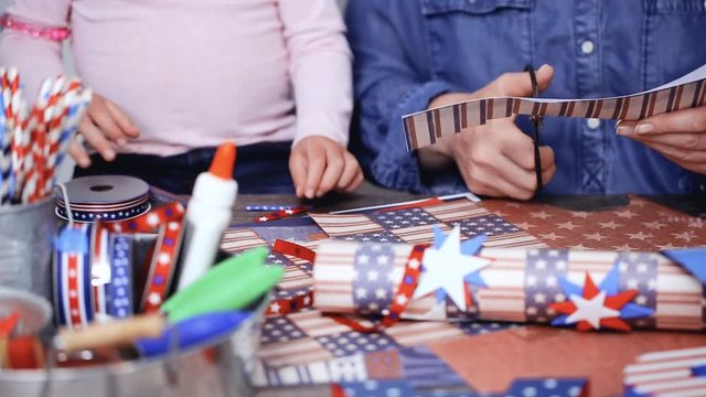 Step by step. Mother and daughter making paper lantern for July 4th celebration