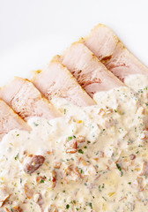 sauce of chanterellas, onion, white wine, parsley, and sour cream on oven baked pork slices