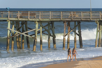 2 teenage girls walking along the beach