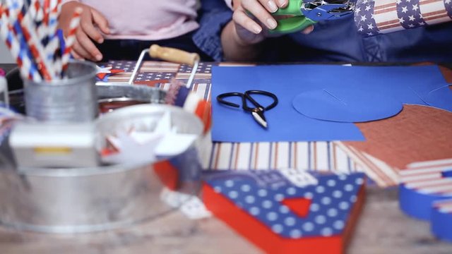 Step by step. Mother and daughter making paper firecrackers for July 4th celebration