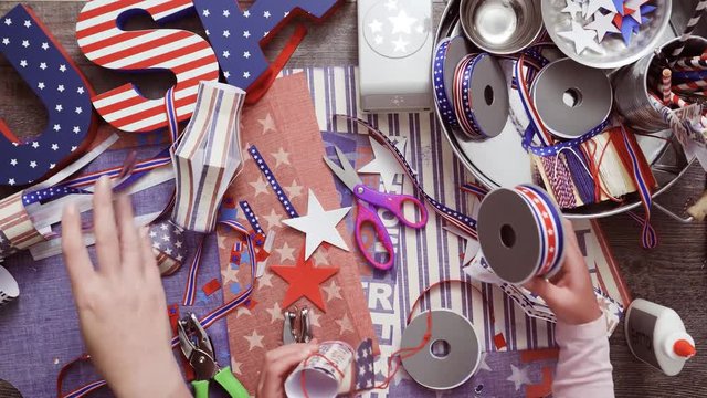 Step by step. Mother and daughter making paper firecrackers for July 4th celebration