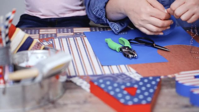 Step by step. Mother and daughter making paper firecrackers for July 4th celebration