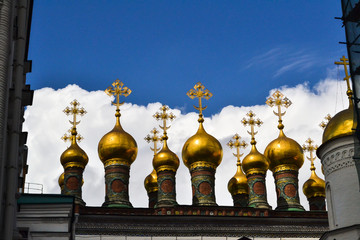 Golden Orthodox crosses and domes of the Church of the Nativity (Verkhospasskiy Sobor) at Kremlin, Moscow with blue sky