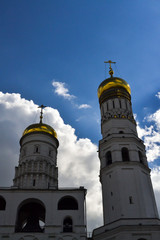 Fototapeta premium Two towers of the bell tower of Ivan the Great opposite the blue sky. Bottom view