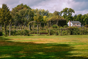 Wide shot of a flower garden with gazebo next to a lonely house