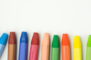 Row of Colorful Multicolored Pastel Wax Crayons on White Paper. Back to School Kids Arts Creativity Drawing Hobby Concept. Poster Banner Template with Copy Space