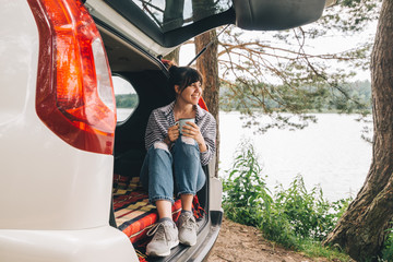 woman sitting in suv trunk. car travel concept. summer time