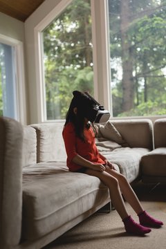 Girl using virtual reality glasses in living room