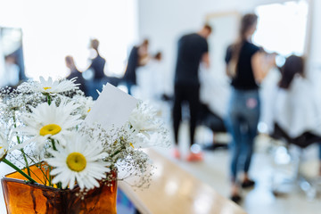 haircut saloon on background. chamomile in vase close up