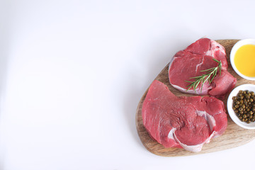 Fresh raw meat beef steak olive oil Spices Pepper Rosemary Cooking concept White background Top view Copy space Flat lay