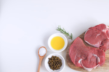 Fresh raw meat beef steak olive oil Spices Pepper Rosemary Cooking concept Cooking concept White background Top view Copy space Flat lay