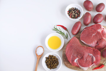 Fresh raw meat beef steak olive oil Spices Hot Salt Wooden spoon Pepper Rosemary Cooking concept Cooking concept White background Top view Copy space Flat lay