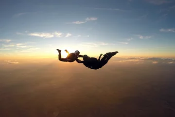 Cercles muraux Sports aériens Skydivers having fun at the amazing sunset