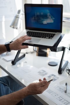Man preparing architectural design on laptop at home