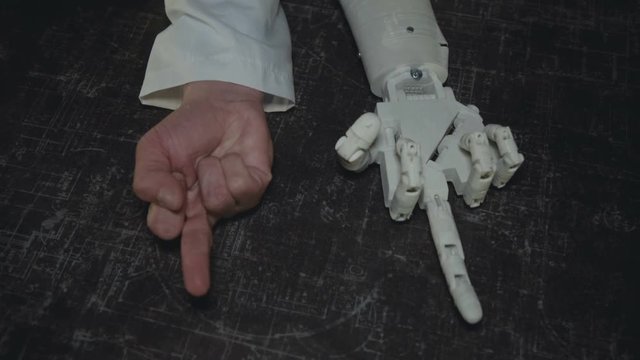 Synchronously repeating the gestures of real and prosthetic hands on background