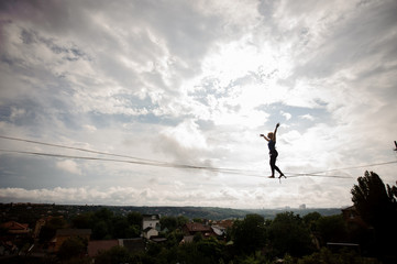 Young woman making steps on the slackline rope