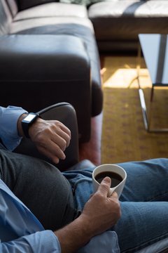 Man checking time while having coffee at home
