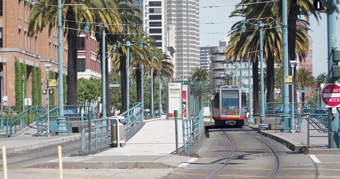Muni train driving down the Embarcadero about to go underground towards Market Street towards Castro district.