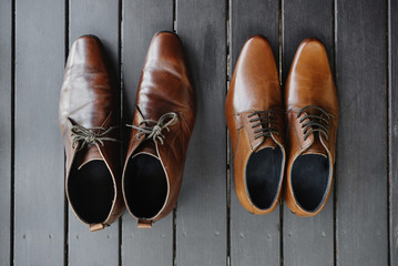 Close-up men's leather brown shoes on the black wooden floor, close-up