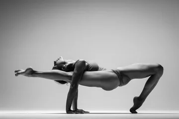 Fotobehang Young beautiful yoga woman is posing in studio. Black and white © Alexander Y